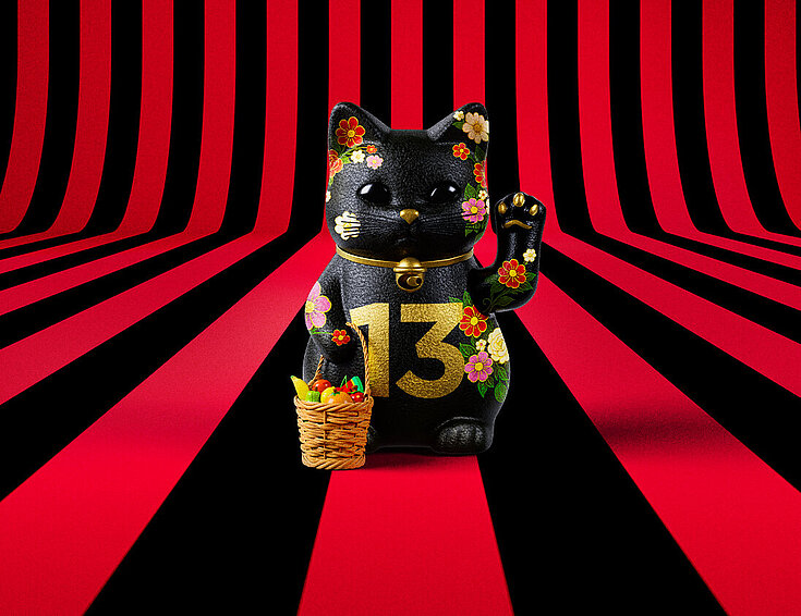 13er Glückskatze mit Blumen und Korb auf rot-schwarz-gestreiftem Hintergrund