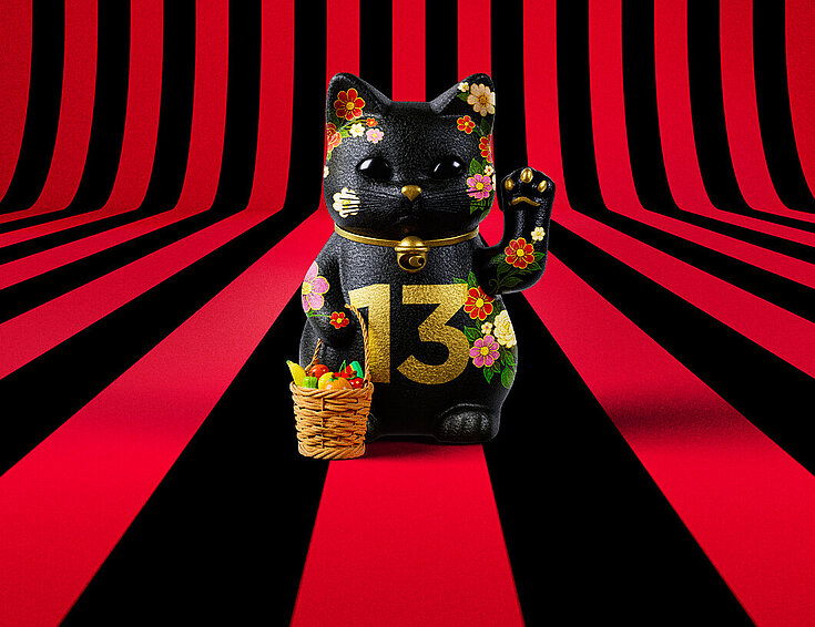 13er Glückskatze mit Blumen und Korb auf rot-schwarz-gestreiftem Hintergrund