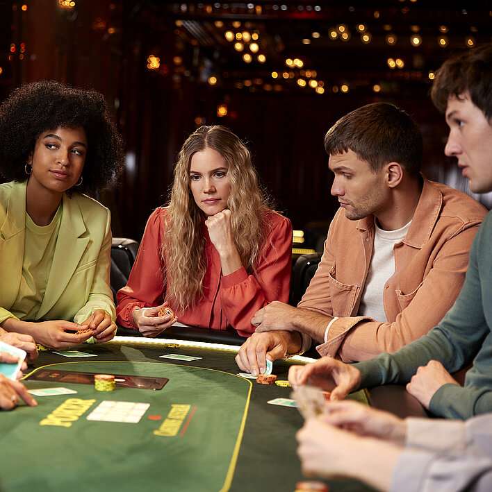 Gruppe mit Karten am Pokertisch