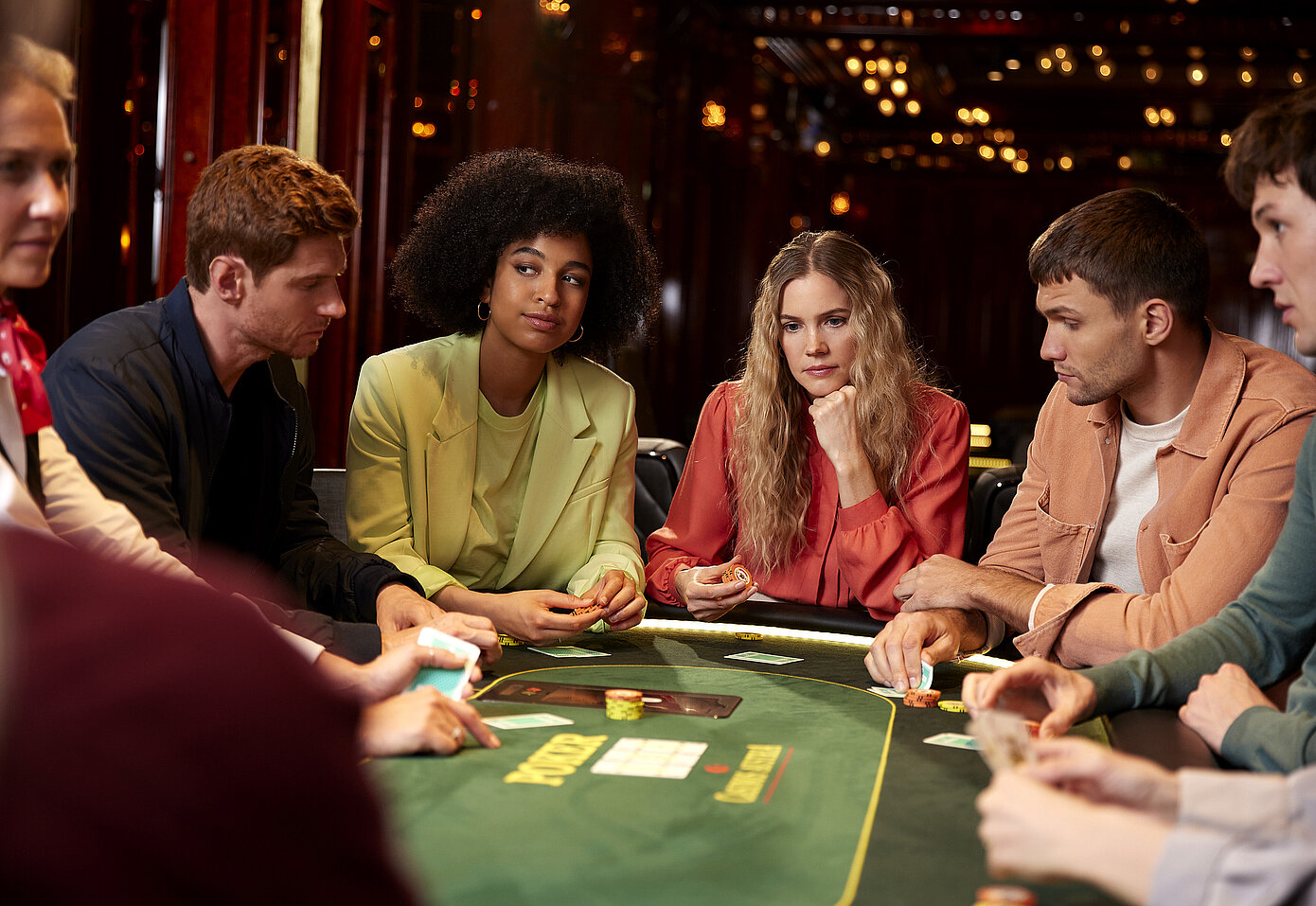 Gruppe mit Karten am Pokertisch