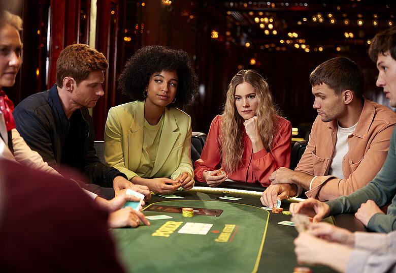 Gruppe mit Karten am Pokertisch