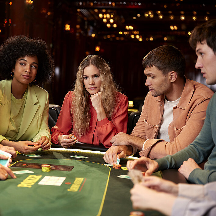 Gruppe mit Karten am Pokertisch