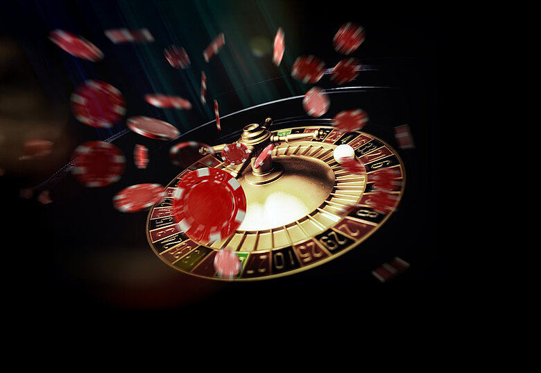 Roulette-Kessel mit fliegenden Jetons auf dunklem Hintergrund Xperience Day Key-Visual