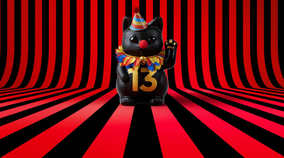 13er Glückskatze mit Faschings-Hut auf rot-schwarz-gestreiftem Hintergrund