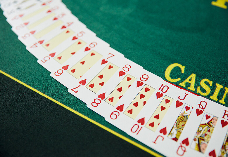 Nahaufnahme eines Casino Poker Tisches mit aufgelegten Spielkarten