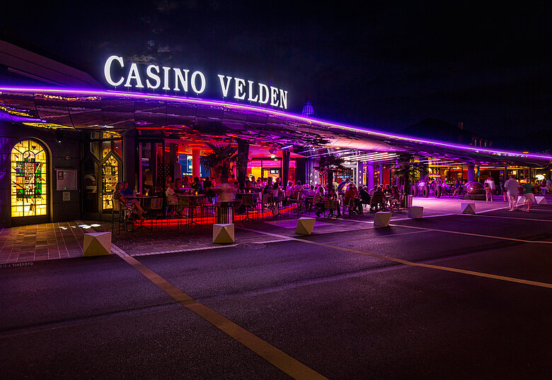 Casino Velden Außenansicht bei Nacht mit violetter Beleuchtung