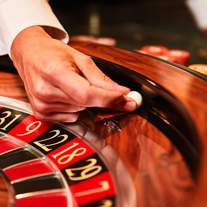 Croupier-Hand mit Kugel beim Roulette