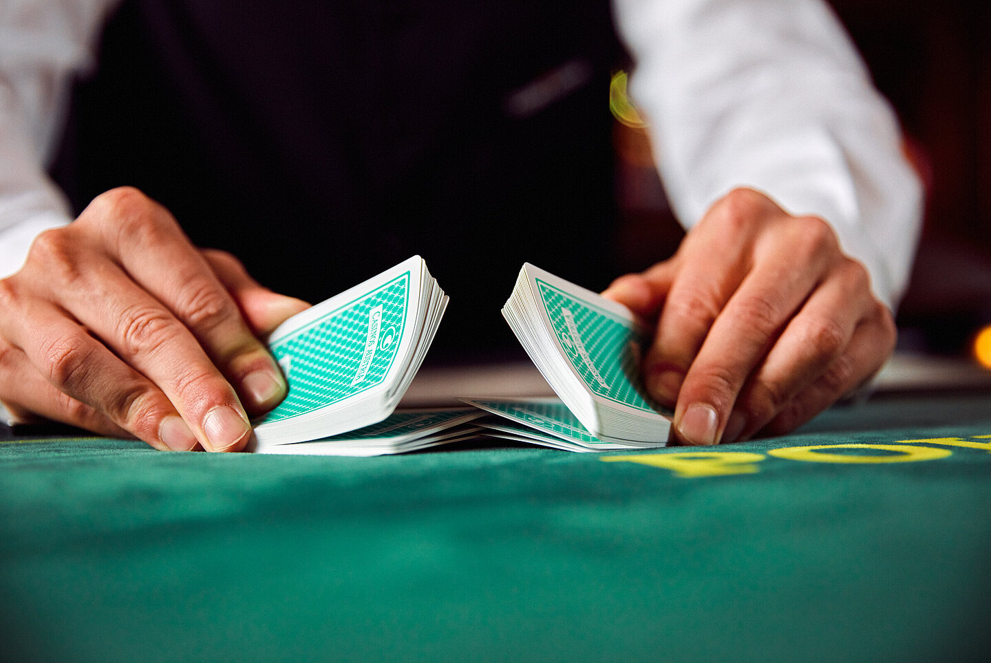 Nahaufnahme von Croupier-Händen die Karten mischen