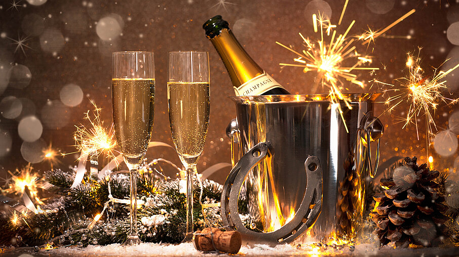 Sektflöten mit Sektflasche, Hufeisen und Wunderkerzen