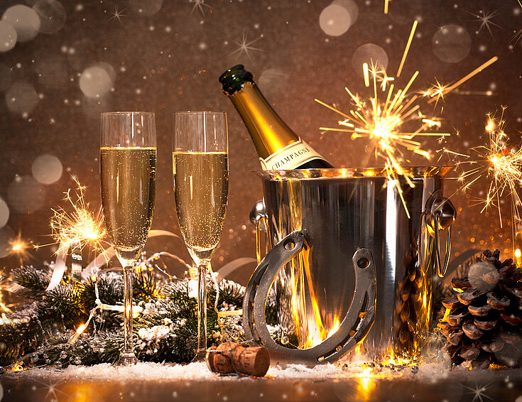 Shutterstock Sektflöten mit Sektflasche, Hufeisen und Wunderkerzen