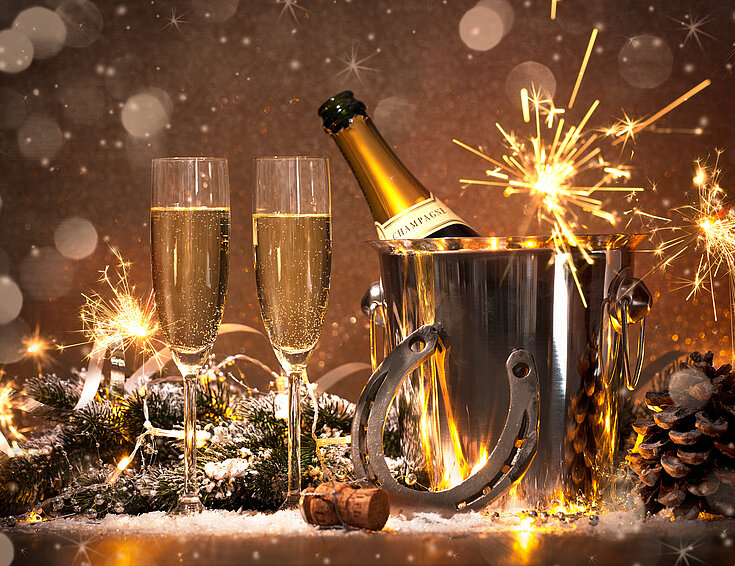 Shutterstock Sektflöten mit Sektflasche, Hufeisen und Wunderkerzen