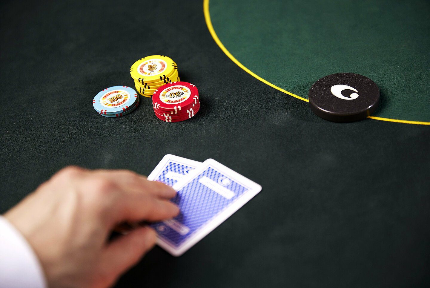 Poker cards face down with dealer button