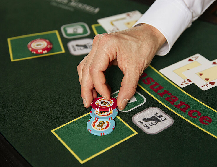 Casinos Austria Black Jack Tableau Close-up Jetons Karten Croupierhand