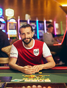 Casino Cup Poker Spieler mit Fußball-Trikot am Poker-Tisch