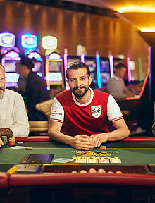 Casino Cup Poker Spieler mit Fußball-Trikot am Poker-Tisch