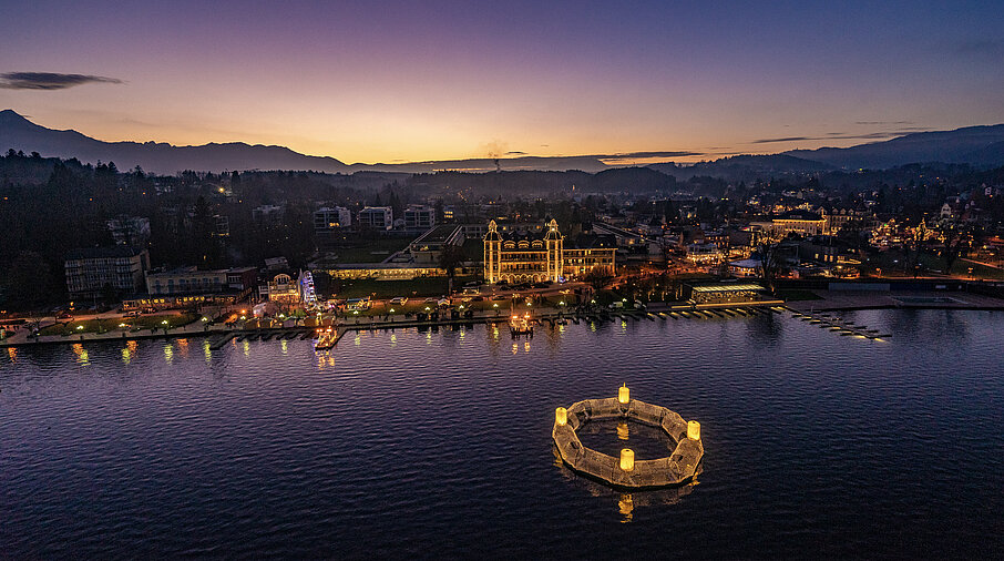 Wörthersee bei Dämmerung - ein schwimmender Adventkranz erhellt die Nacht.