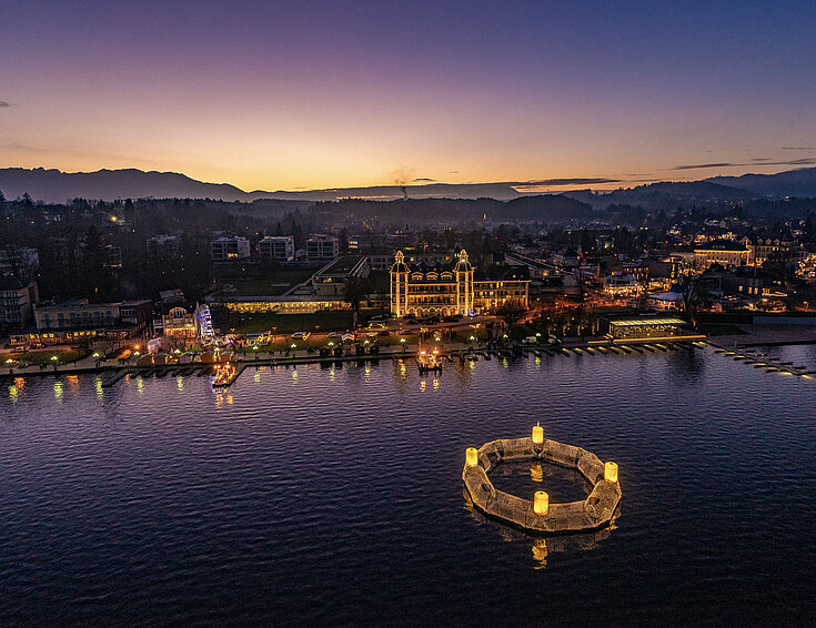 Wörthersee bei Dämmerung - ein schwimmender Adventkranz erhellt die Nacht.