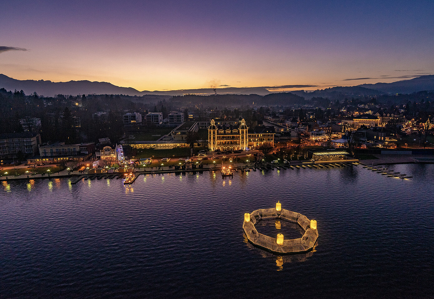 Wörthersee bei Dämmerung - ein schwimmender Adventkranz erhellt die Nacht.