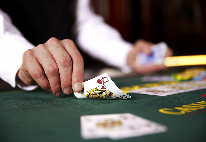Croupier deckt Karten am Poker Tisch auf