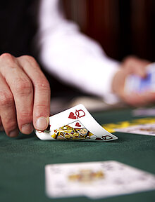 Croupier deckt Karten am Poker Tisch auf