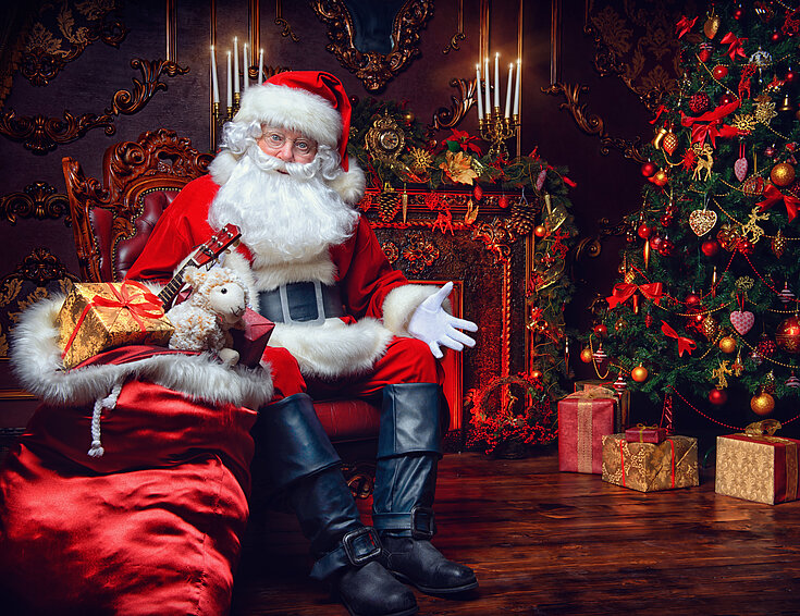 Weihnachtsmann im Sessel mit Geschenken