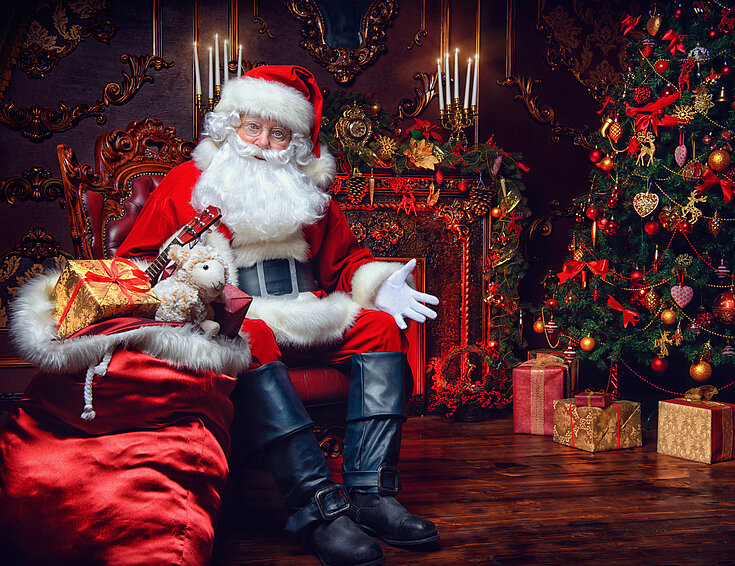 Shutterstock Weihnachtsmann im Sessel mit Geschenken
