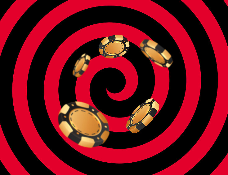 Gold-schwarze Casino Jetons auf schwarz-rotem Hintergrund