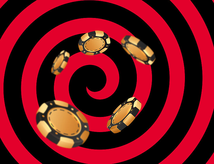 Gold-schwarze Casino Jetons auf schwarz-rotem Hintergrund