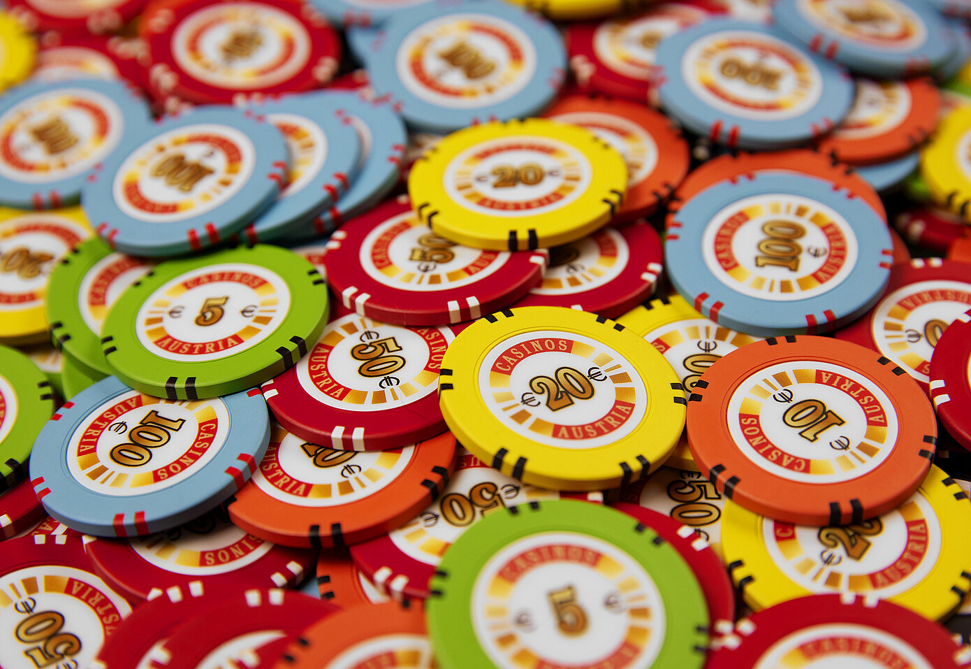 Mehrfarbige Jetons mit Casinos Austria Branding aus der Vogelperspektive.